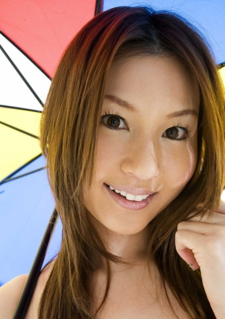 Sexy Japanese girl Tatsumi Yui holds an umbrella while standing naked