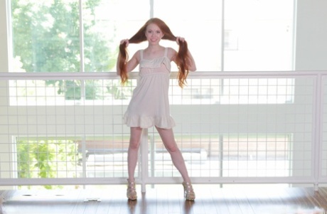 Foxy redhead Dolly Little stripping and playing with her pussy lips