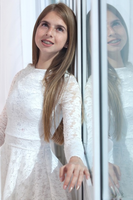 Young looking girl Rina takes off her pretty dress to model totally naked