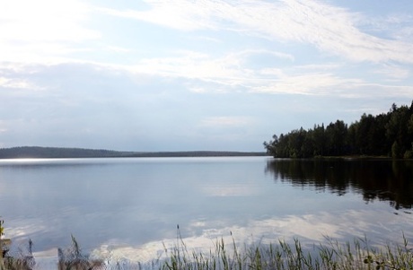 Girl next door Megan pulls out her tits while sitting on a rock in the lake