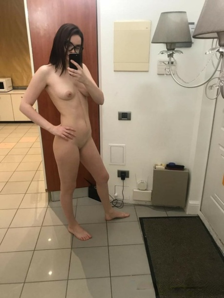 Brunette babe in glasses takes nudes showing her small tits & her shaved twat