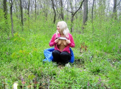 Blonde amateur Adele exposes her boobs and butt while in a forest setting