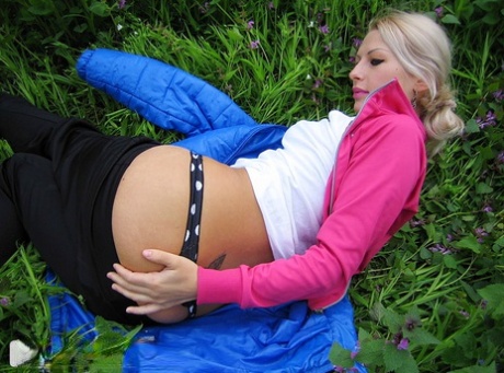 Blonde amateur Adele exposes her boobs and butt while in a forest setting