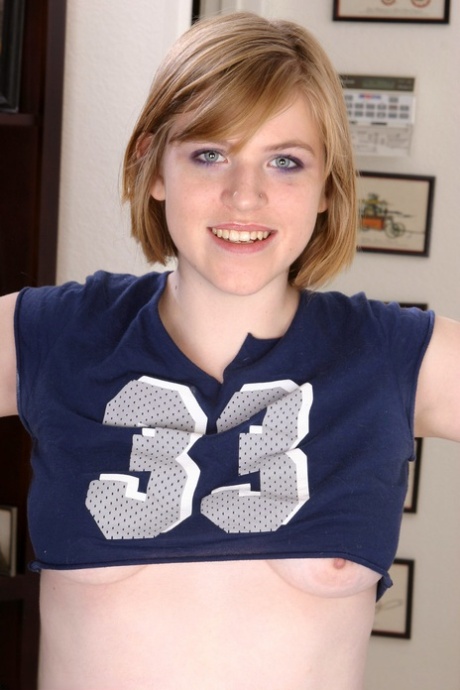 Blonde cheerleader Elizabeth shows off her tits & spreads her shaved pussy