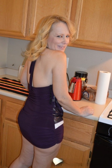 Mature blonde strips in the kitchen & rubs her juicy tits and hot pussy