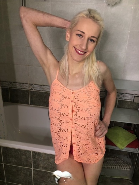 Blonde amateur shows off her saggy breasts and her big clit in the bathroom
