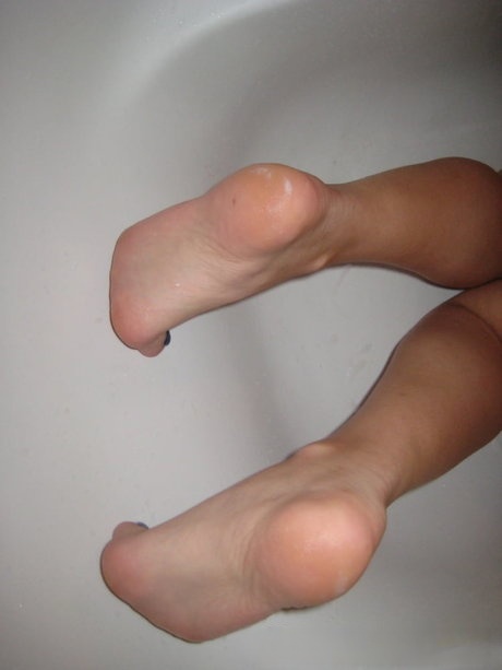 Brunette amateur licks her fingers and rubs her vagina in a tub