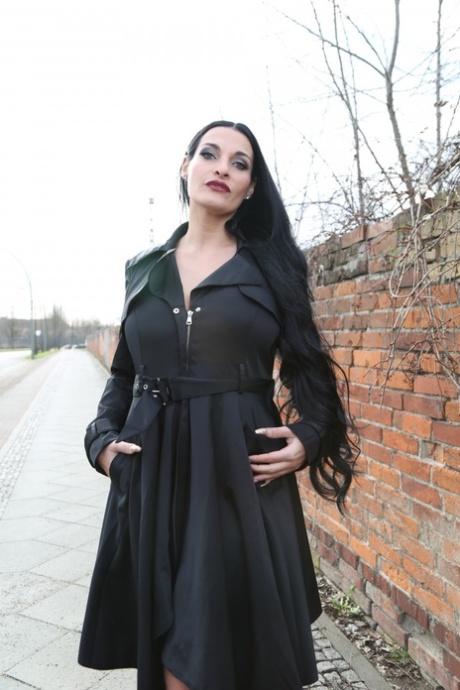 Gorgeous black haired German MILF reveals bulbous & massive big tits outdoors