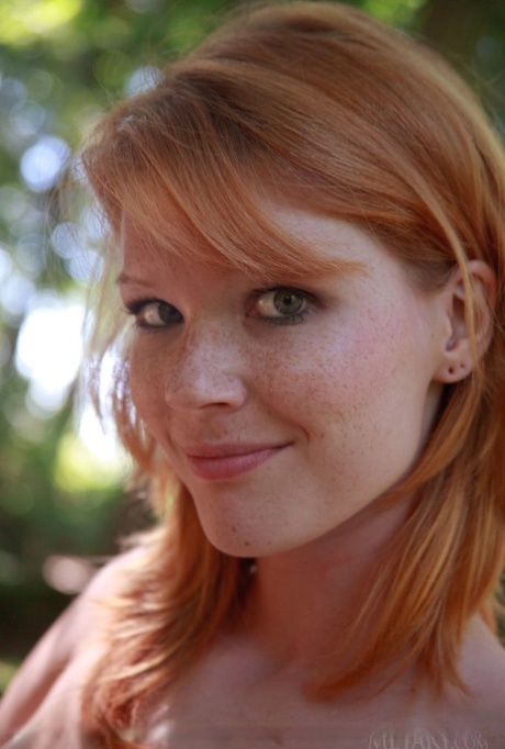 Nude redhead Mia Sollis flaunts her well formed body on cut line in forest