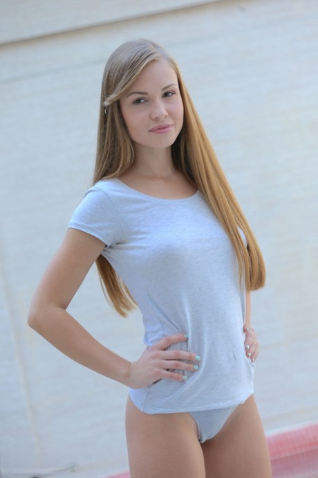 Cute teen blonde Megan flashes her nice tits and disrobes to reveal bald pussy