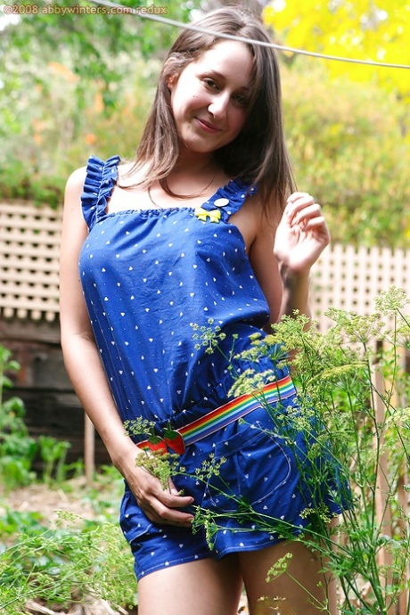 Slender amateur Petria slides jumpsuit down long legs outdoors