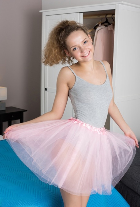 Tiny teen Faina removes tutu and onesie to model naked on her bed