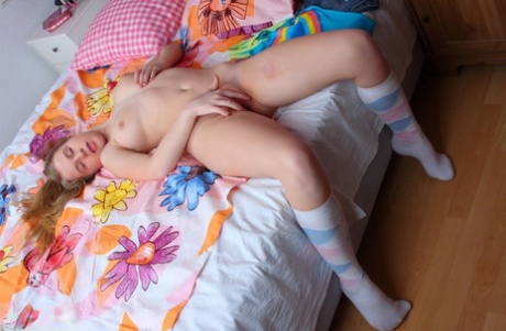 Young looking girl plays with her firm boobs and bald pussy in the nude