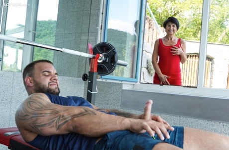 Lusty granny Petra T gets fucked by a muscular tattooed dude at the gym