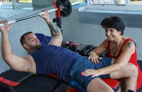Lusty granny Petra T gets fucked by a muscular tattooed dude at the gym