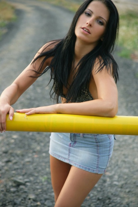 Sexy brunette Mili Jay slips off micro skirt to strut on beach string bikini