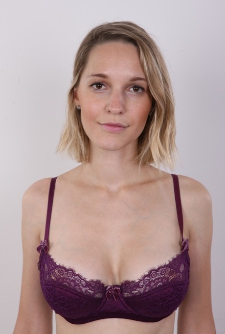 European female Tereza wears no expression while undressing for rent money