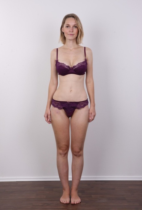 European female Tereza wears no expression while undressing for rent money