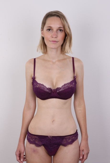 European female Tereza wears no expression while undressing for rent money