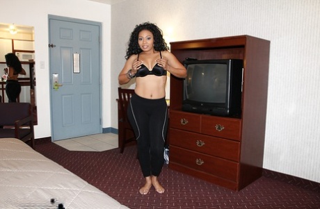 Curly-haired ebony chick with ample booty slowly getting rid of her clothes