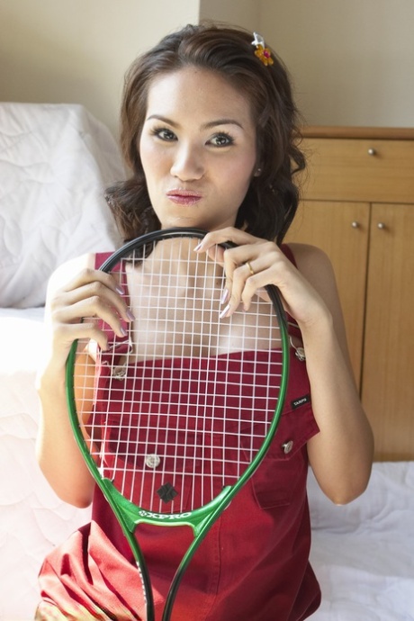 Shemale tennis player from Asia never puts aside her racket even posing naked