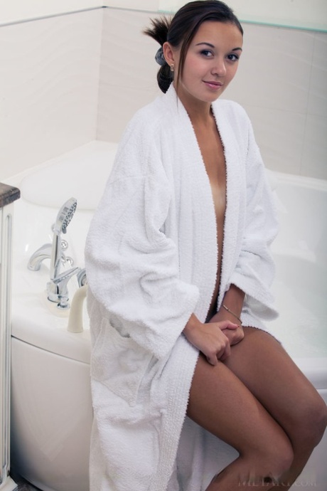 Wet European babe exposing small teen breasts and shaved cunt in bathtub