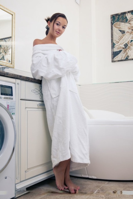 Wet European babe exposing small teen breasts and shaved cunt in bathtub