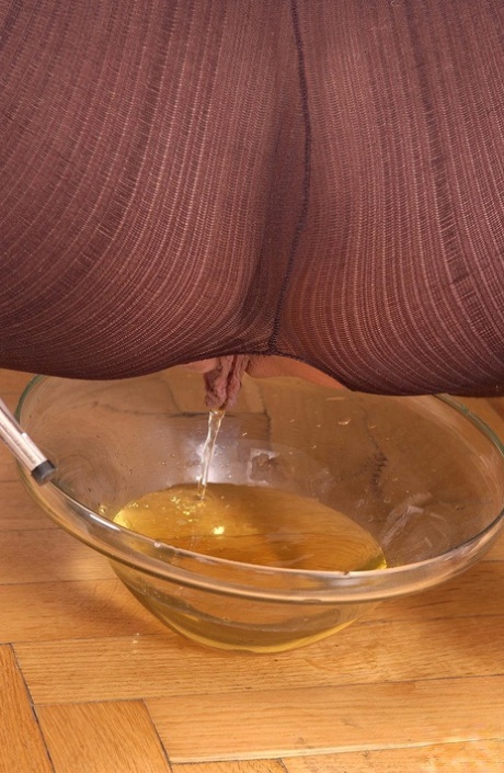 Hot chick Sandy pisses into a glass dish wearing a crotchless bodystocking