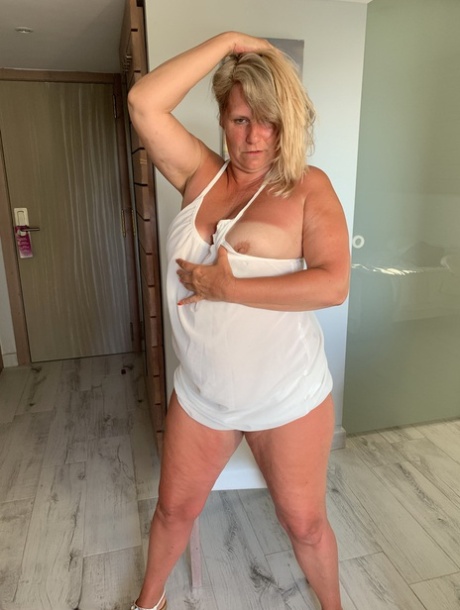 Thick older woman Sweet Susi exposes tan lined tits after hiking up her dress