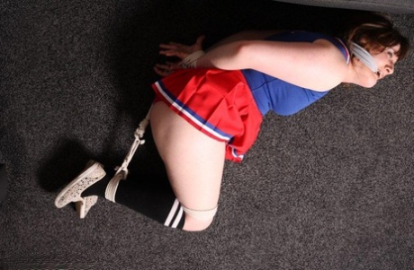 Overweight girl is left alone while tied up and gagged in a cheerleader outfit