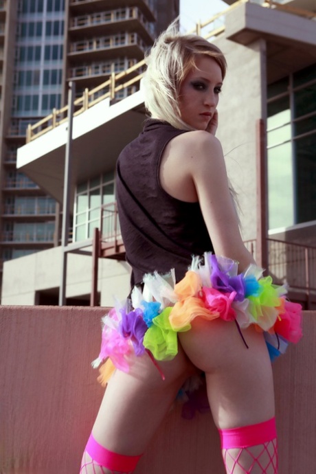 Blonde teen Kiki flashes her perky tits and sexy ass while on a rooftop