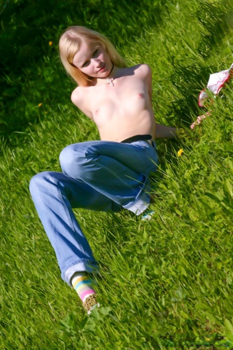 Pretty blonde teen Yana F shows off her petite naked body outdoors