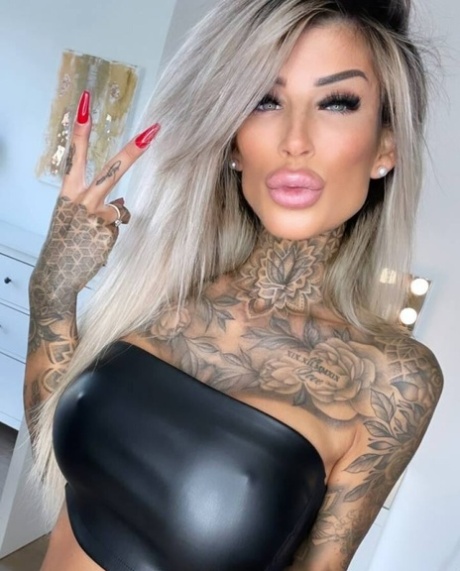 Tattooed amateur teases with her stunning curves in hot outfits