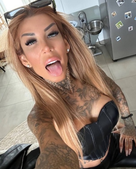 Tattooed amateur teases with her stunning curves in hot outfits