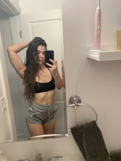 Amateur model holds her bare ass during a series of nude selfies