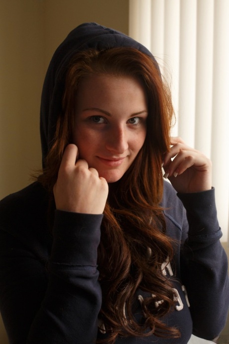 Sassy redhead girlfriend Emmy Sinclair shows her big tits and her juicy curves