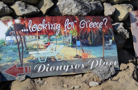 Thick blonde woman with big boobs wanders around a nude beach in a straw hat