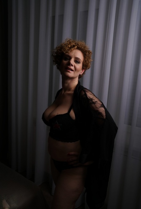 Natural redhead with curly hair blows a kiss after wetting her twat in bathtub