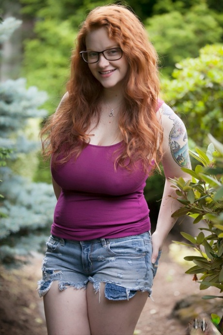 Natural redhead teen exposes her thick body and big saggy boobs in the woods