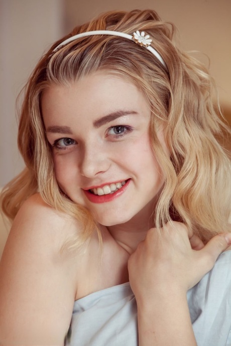 Young blonde sinks a couple of fingers in her pussy after stripping to socks