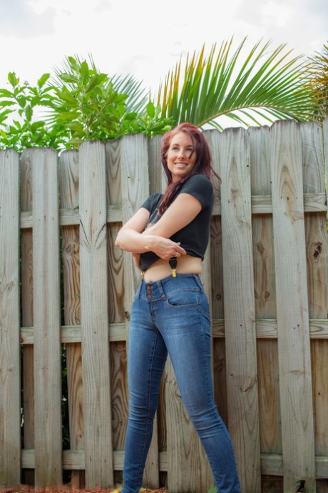Hot redhead Andy Adams loses her t-shirt & jeans in the yard to pose naked